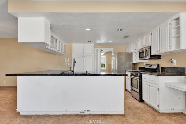 kitchen with stainless steel appliances, white cabinets, kitchen peninsula, and sink