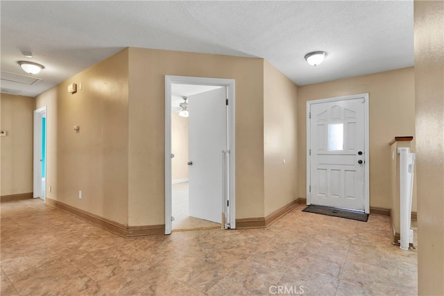 foyer with ceiling fan, a textured ceiling, and water heater