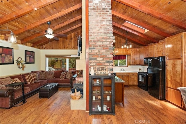 living room featuring ceiling fan, light hardwood / wood-style floors, a skylight, high vaulted ceiling, and beam ceiling