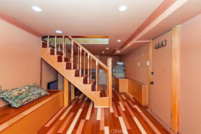 stairway with hardwood / wood-style floors and ornamental molding