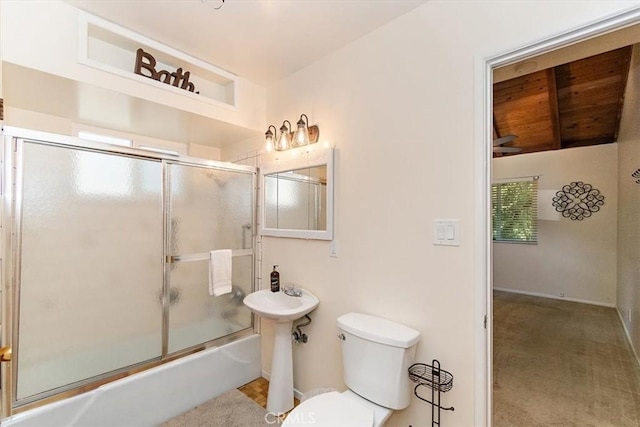 full bathroom featuring sink, shower / bath combination with glass door, and toilet