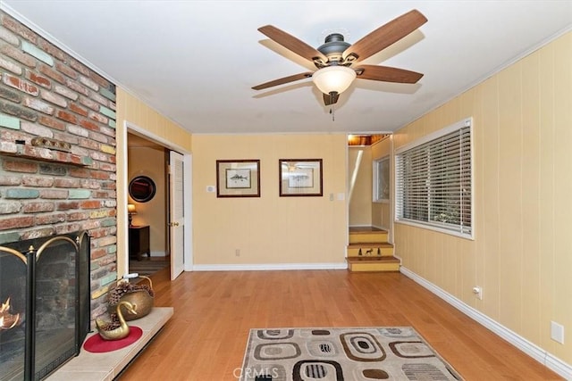 unfurnished living room with light hardwood / wood-style floors, ceiling fan, and a brick fireplace