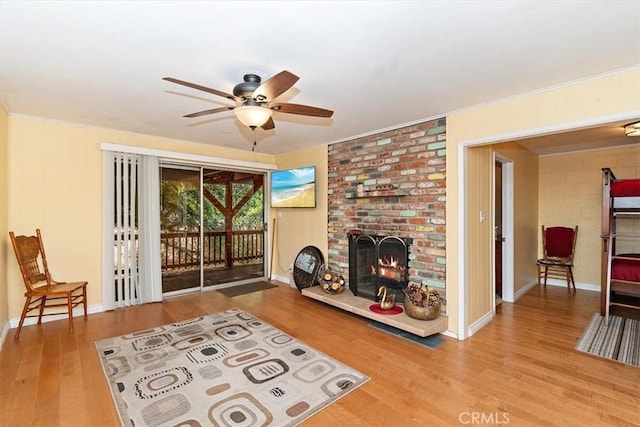 living room with a fireplace, ceiling fan, and light hardwood / wood-style floors