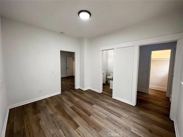 unfurnished bedroom with dark wood finished floors and baseboards