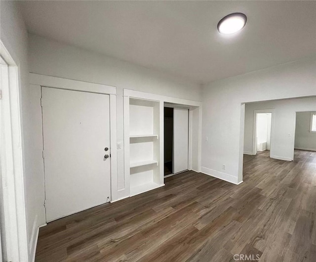 unfurnished bedroom featuring dark wood-style flooring and baseboards