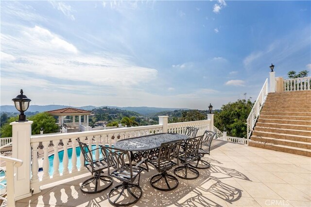 view of patio featuring a gazebo, a mountain view, and a community pool