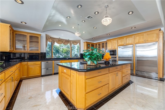 kitchen featuring lofted ceiling, hanging light fixtures, built in appliances, tasteful backsplash, and a kitchen island