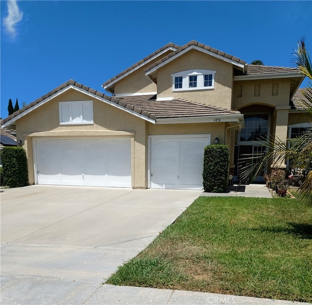 view of front of property with a garage and a front lawn