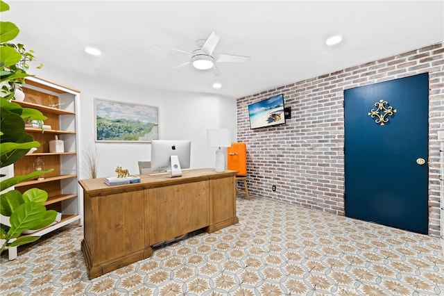 office area with ceiling fan and brick wall