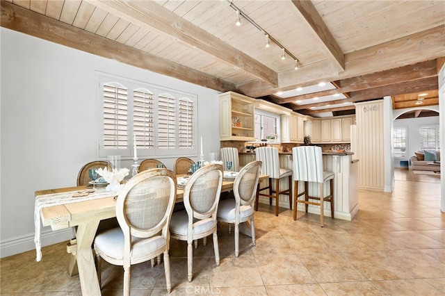 tiled dining area featuring wooden ceiling and beam ceiling