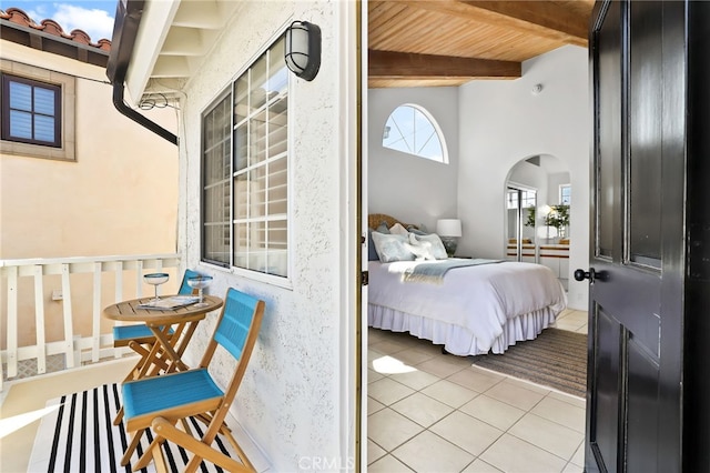 tiled bedroom featuring wooden ceiling and beam ceiling