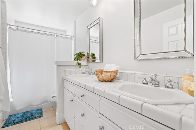 bathroom featuring vanity, tile patterned floors, and toilet