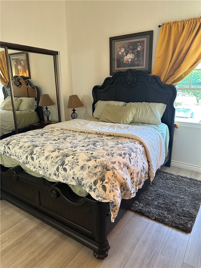 bedroom with light hardwood / wood-style floors and a closet