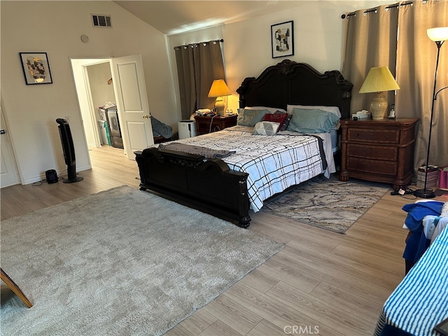 bedroom featuring vaulted ceiling and light hardwood / wood-style flooring