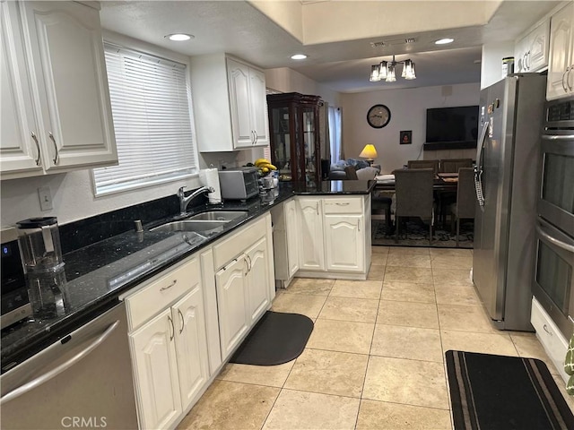 kitchen featuring white cabinetry, appliances with stainless steel finishes, kitchen peninsula, and sink