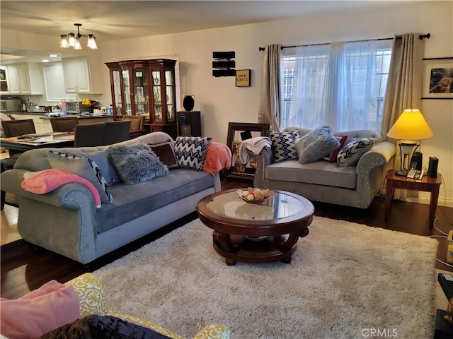 living room with dark hardwood / wood-style floors and an inviting chandelier