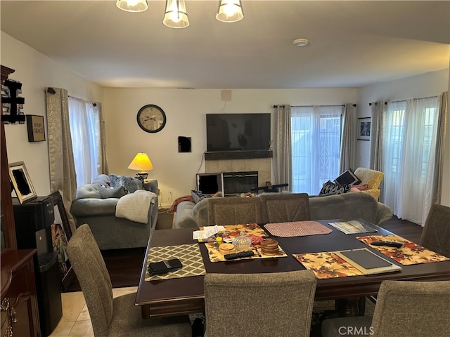 dining space featuring a fireplace and light tile patterned floors