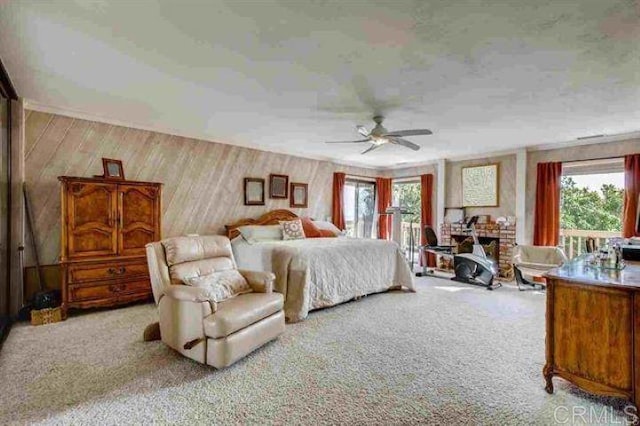 carpeted bedroom featuring wood walls and ceiling fan