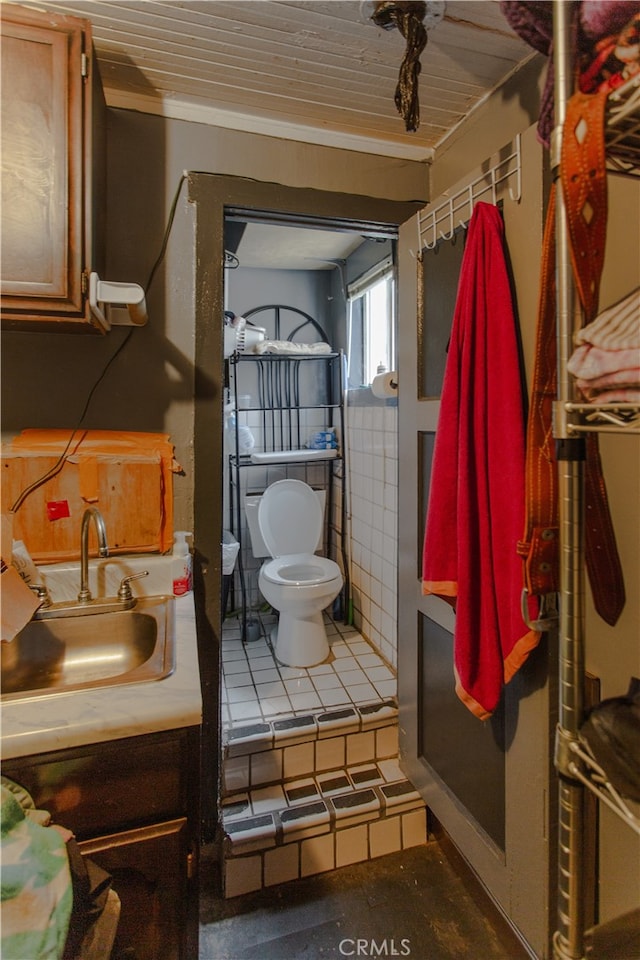 bathroom with ornamental molding, vanity, and toilet