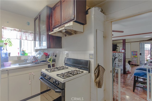 kitchen with white gas range, decorative backsplash, and ceiling fan