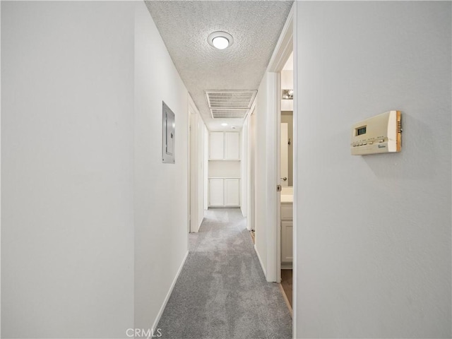 corridor featuring electric panel, carpet, and a textured ceiling