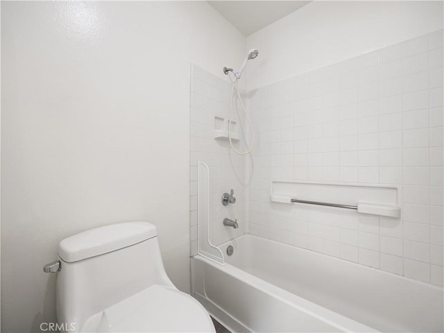 bathroom with tiled shower / bath combo and toilet