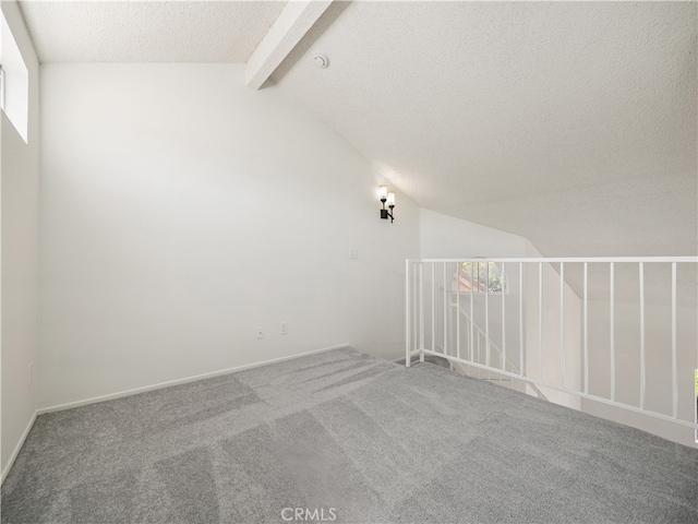 additional living space featuring vaulted ceiling with beams, carpet floors, and a textured ceiling