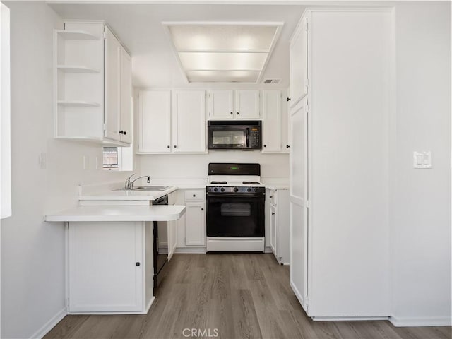 19810 Sandpiper Pl Unit 22, Newhall, CA 91321 - kitchen with white cabinets, open shelves, light wood finished floors, and black appliances