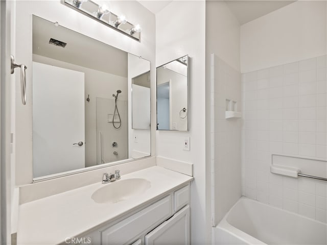 bathroom featuring tiled shower / bath and vanity