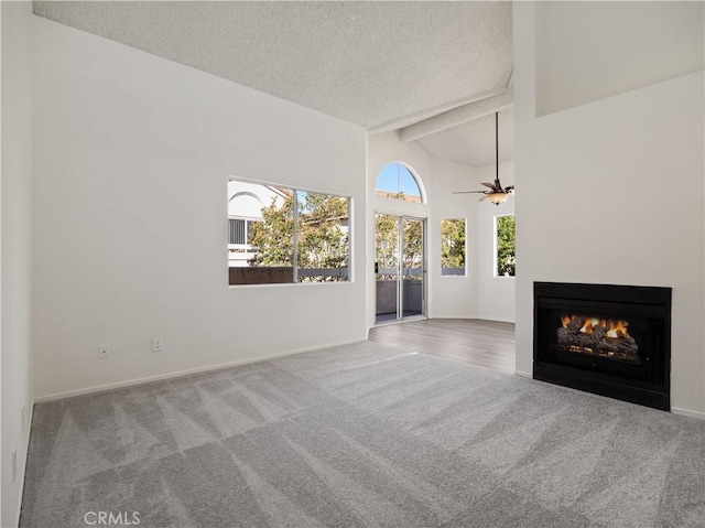 unfurnished living room with ceiling fan, high vaulted ceiling, carpet, a textured ceiling, and beamed ceiling