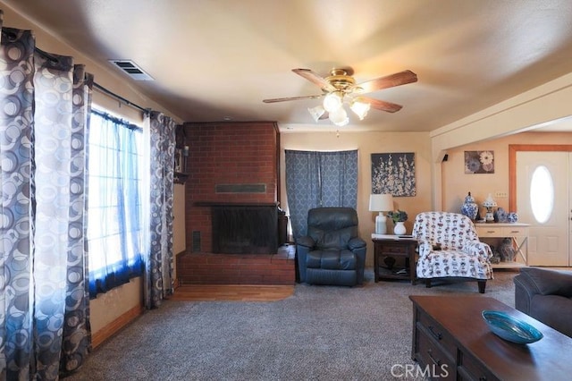 living room with a fireplace, carpet, and ceiling fan