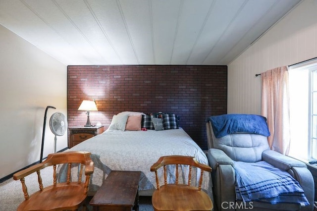 carpeted bedroom with brick wall