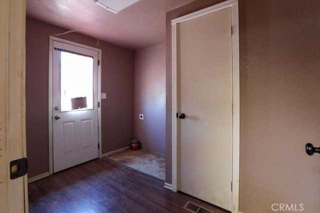 entryway with dark hardwood / wood-style flooring and a textured ceiling