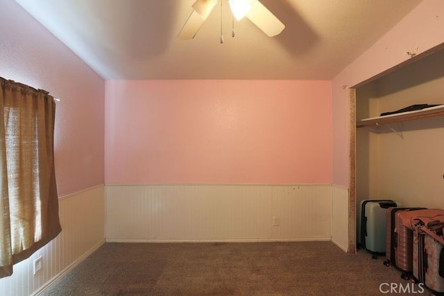 unfurnished bedroom with dark colored carpet, ceiling fan, and a closet