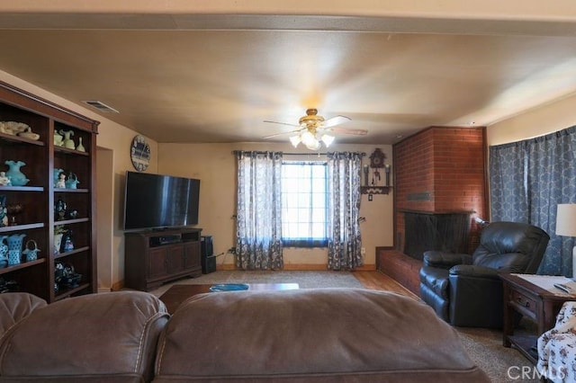 living room featuring ceiling fan and a fireplace