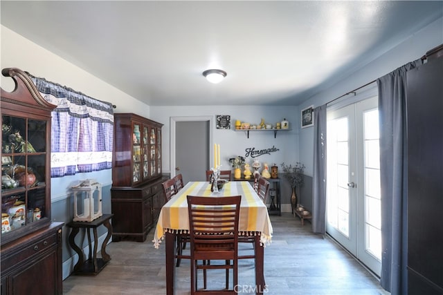 dining room featuring french doors, a healthy amount of sunlight, and hardwood / wood-style flooring