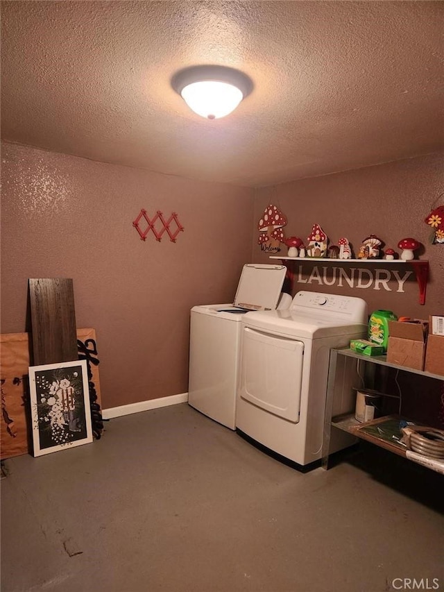 washroom with washing machine and clothes dryer and a textured ceiling