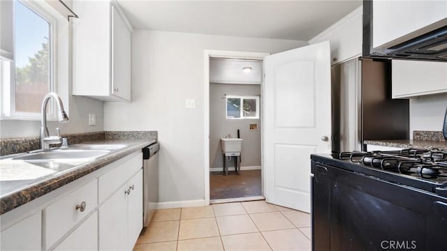 kitchen with white cabinetry, gas stove, light tile patterned flooring, stainless steel dishwasher, and sink