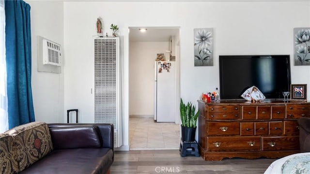 living room with hardwood / wood-style flooring and an AC wall unit