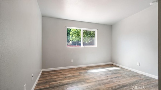 unfurnished room with dark hardwood / wood-style flooring