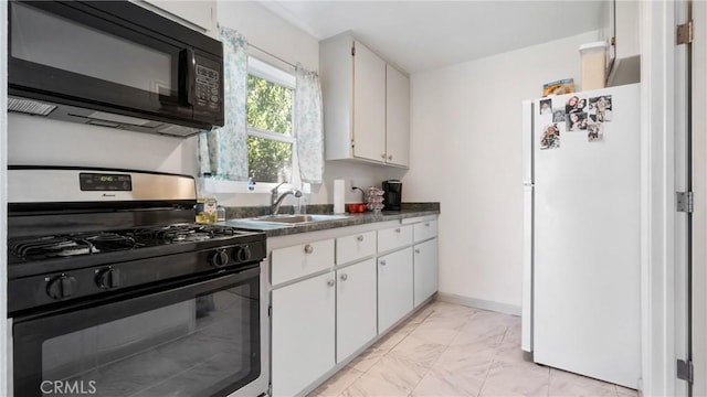 kitchen featuring white cabinets, sink, gas range, and white refrigerator