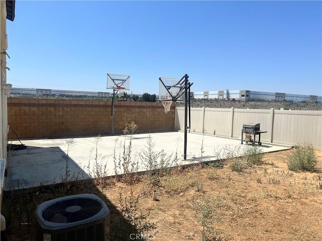 view of yard with cooling unit and basketball court