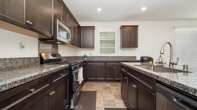 5345 Blue Ridge Way, Fontana, CA 92336 - kitchen with dark brown cabinets, recessed lighting, dark stone counters, a sink, and appliances with stainless steel finishes