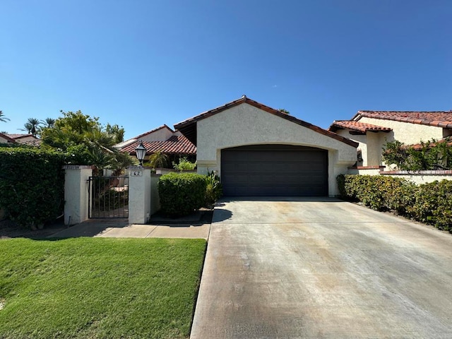 mediterranean / spanish home featuring a front yard and a garage