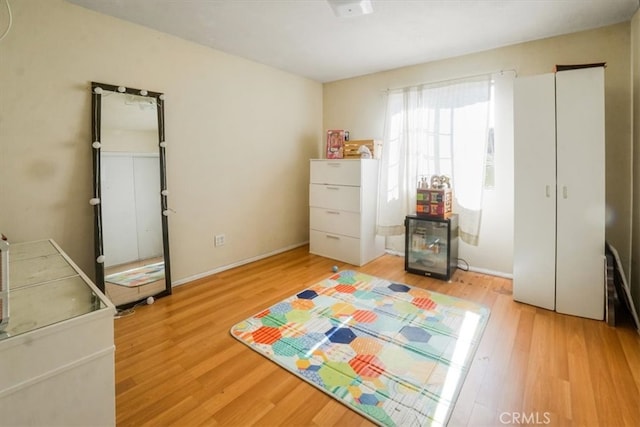 bedroom featuring light wood-style floors and baseboards