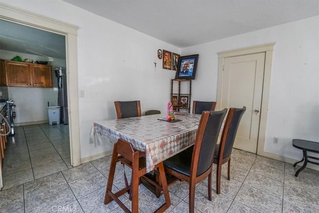 dining room with light tile patterned floors and baseboards