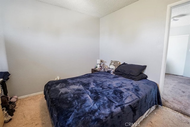 carpeted bedroom with a textured ceiling and baseboards