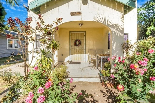 view of exterior entry featuring a patio area and stucco siding