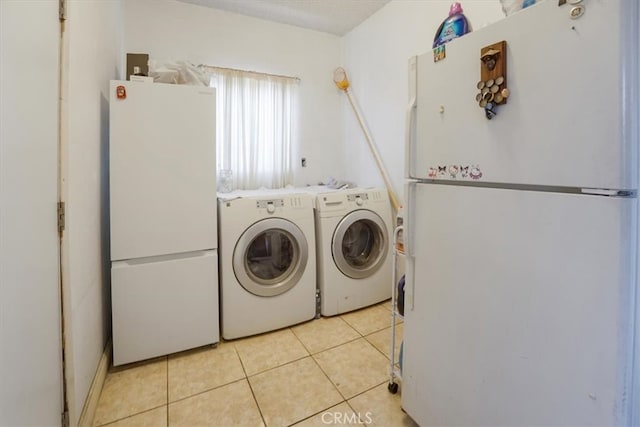 clothes washing area featuring light tile patterned floors, laundry area, and washer and clothes dryer