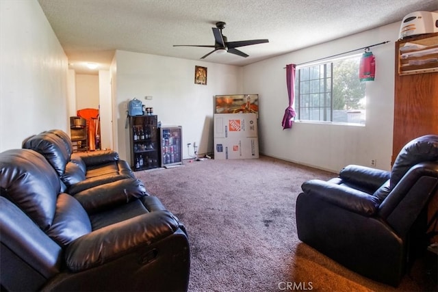 living room with a ceiling fan, carpet flooring, and a textured ceiling